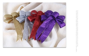Close-up of sparkling glitter bows in gold, silver, red, and purple for Christmas trees