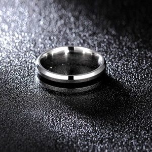 Macro shot of silver titanium ring with black enamel stripe and polished metal finish