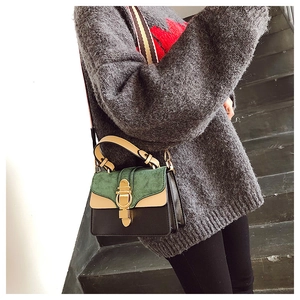 Detailed close-up of a tri-color leather handbag featuring a gold ring clasp and striped strap