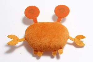 Close-up of orange plush crab toy with felt details and Velcro paws on white background