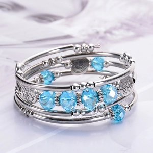 Macro detail of multi-layer beaded bracelet with tree of life and heart charms