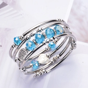 Detail of silver spiral multi-layer bracelet with blue crystal beads and leaf charms