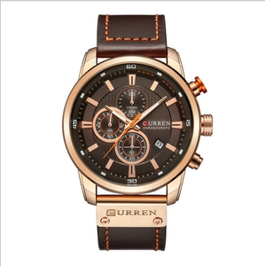Detail of rose gold chronograph watch with brown leather strap and functional dials