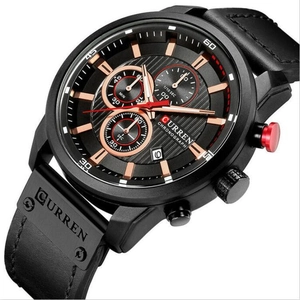 Detailed macro view of black chronograph watch face with rose gold markers and leather strap