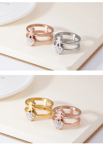 Detail of hollow figure rings with zircon heart charms in gold, silver and rose gold