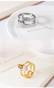 Close-up of double-layered heart rings with zircon charms in gold and silver finish