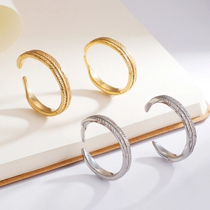 Minimalist feather patterned open rings in gold and silver finish on white background