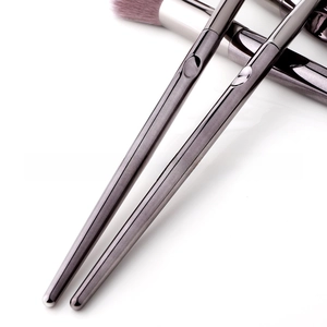 Macro shot of ergonomic metallic makeup brush handles with glossy dark grey finish