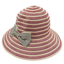 Detail of wide brim sun hat with purple stripes and a decorative black and white bow knot