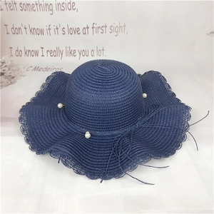 Navy blue wide brim straw hat with wavy edges and pearl accents for women beach travel