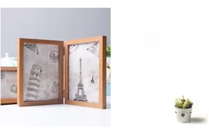 Detail of a foldable double wooden photo frame with vintage architectural prints in white