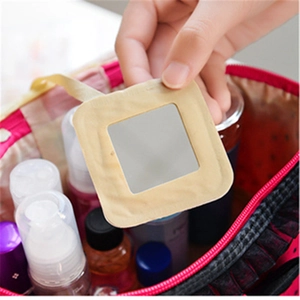 Close-up of portable beige square mirror held by hand showing compact storage size