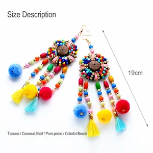 Detalle de pendientes boho de 19cm con borlas de colores, coco y pompones suaves