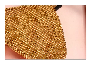 Side view detail of the golden beaded evening clutch bag with glossy metallic finish