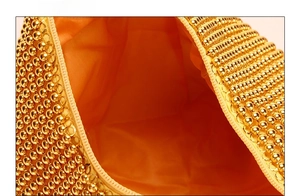 Detail of gold beaded evening bag showing inner fabric lining and metallic craftsmanship