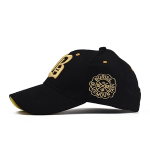 Detail of 3D gold letter B embroidery and round badge on black cotton baseball cap