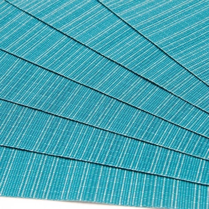 Sets de table en PVC tissé bleu sarcelle et crème avec texture antidérapante
