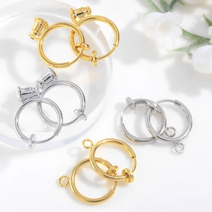 Detail of gold and silver metal ear clip converters and DIY jewelry findings on white