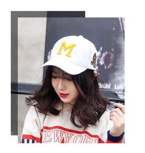 Detail of white cotton baseball cap featuring 3D yellow M and tiger motif embroidery