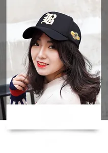 Close-up of black elastic baseball cap with golden B embroidery and bee side patch