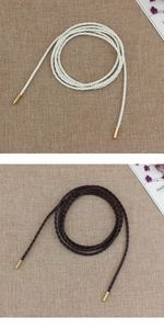 Close-up of white and dark brown woven waist ropes with elegant gold metal tips