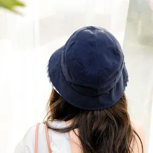 Detail view of navy blue bucket hat featuring a stylish blue and white checkered brim lining