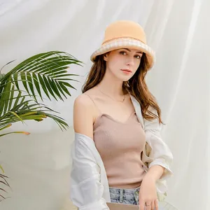 Detail of a yellow fashion bucket hat featuring a plaid lining and cotton-linen texture