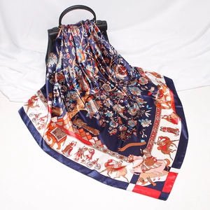 Detail of silk-like square scarf with knight print draped over a black handbag