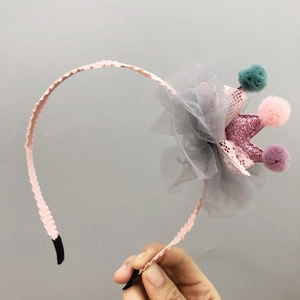 Detail of pink glitter crown hairband with colorful pom-poms and gray mesh flower