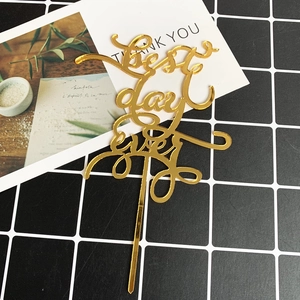 Close-up of golden mirror acrylic Best Day Ever cake topper for wedding celebration