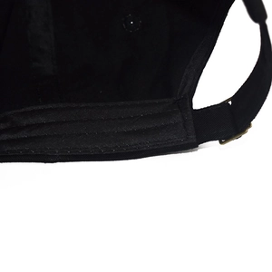 Gros plan de la boucle métallique et des coutures sur la casquette en coton noir