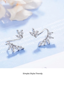 Macro detail of silver leaf drop earrings featuring marquise-cut sparkling zircon stones