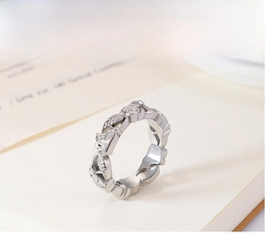 Macro shot of silver ring featuring a continuous rose and leaf embossed pattern