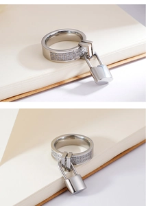 Macro shot of a 6mm silver ring featuring double-row zircons and a small padlock charm