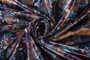 Detailed macro shot of the glossy silk scarf texture with ethnic paisley patterns