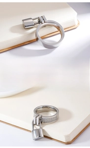 Close-up of minimalist silver lock pendant rings with smooth and diamond-set bands