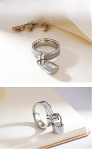 Detailed view of silver 6mm pave-set diamond ring with a dangling cylinder lock charm