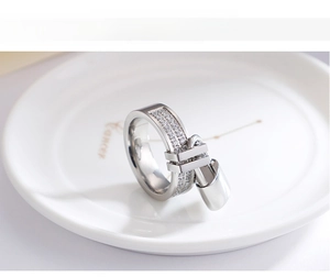 Macro view of a silver 6mm ring featuring double-row crystals and a metal lock pendant