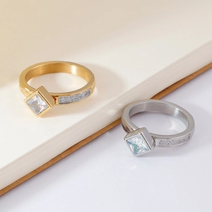 Minimalist square zircon ring in gold and silver finish on a notebook background