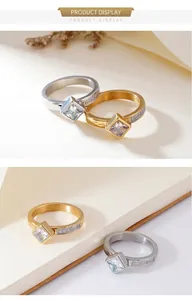 Close-up of gold and silver square zircon rings with side pavé diamonds on book pages