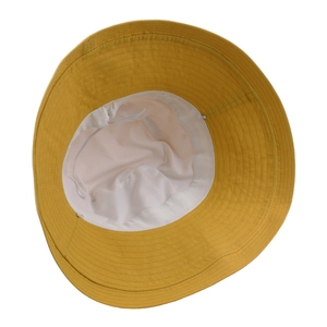 Inside view of a yellow cotton wide brim sun hat showing white lining and stitching detail