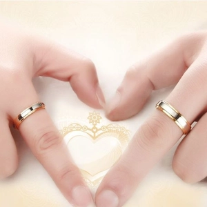Close-up of two-tone gold and silver stainless steel rings for couples on hands
