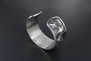 Macro view of vintage punk steel bangle with 3D star patterns and textured finish