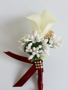 Detail of white calla lily boutonniere with burgundy ribbon and gold diamond accents