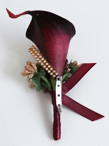 Detailed view of burgundy calla lily boutonniere with gold rhinestones and satin ribbon
