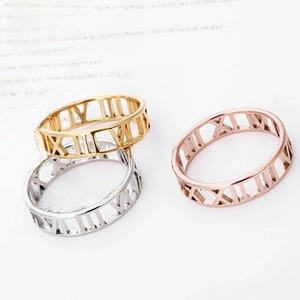 Close-up of stacked stainless steel rings with hollow Roman numeral laser-cut patterns