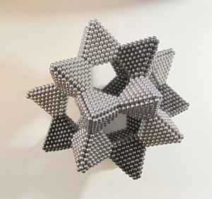 Macro view of silver 5mm magnetic buckyballs forming a hollow geometric star puzzle