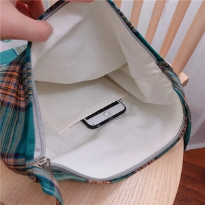 Vue intérieure du sac en toile à carreaux verts montrant la poche interne pour téléphone