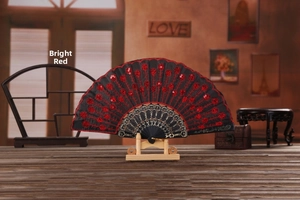 Detail of red floral embroidery and sequins on black folding fan with gold cutout bone