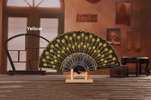Detail of black fabric folding fan with gold sequins and peacock embroidery on a stand